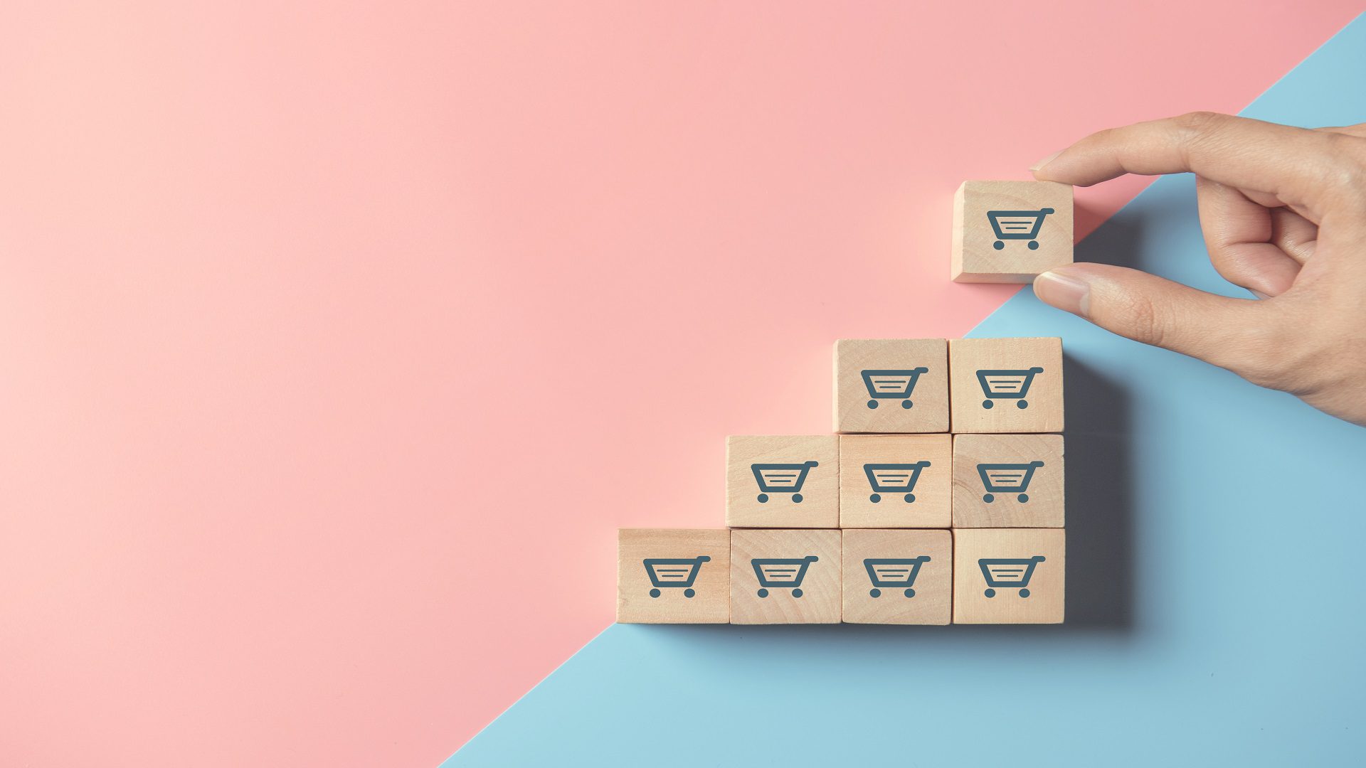 Person stacking blocks with a cart symbol - symbolizes how to grow your SaaS using automation