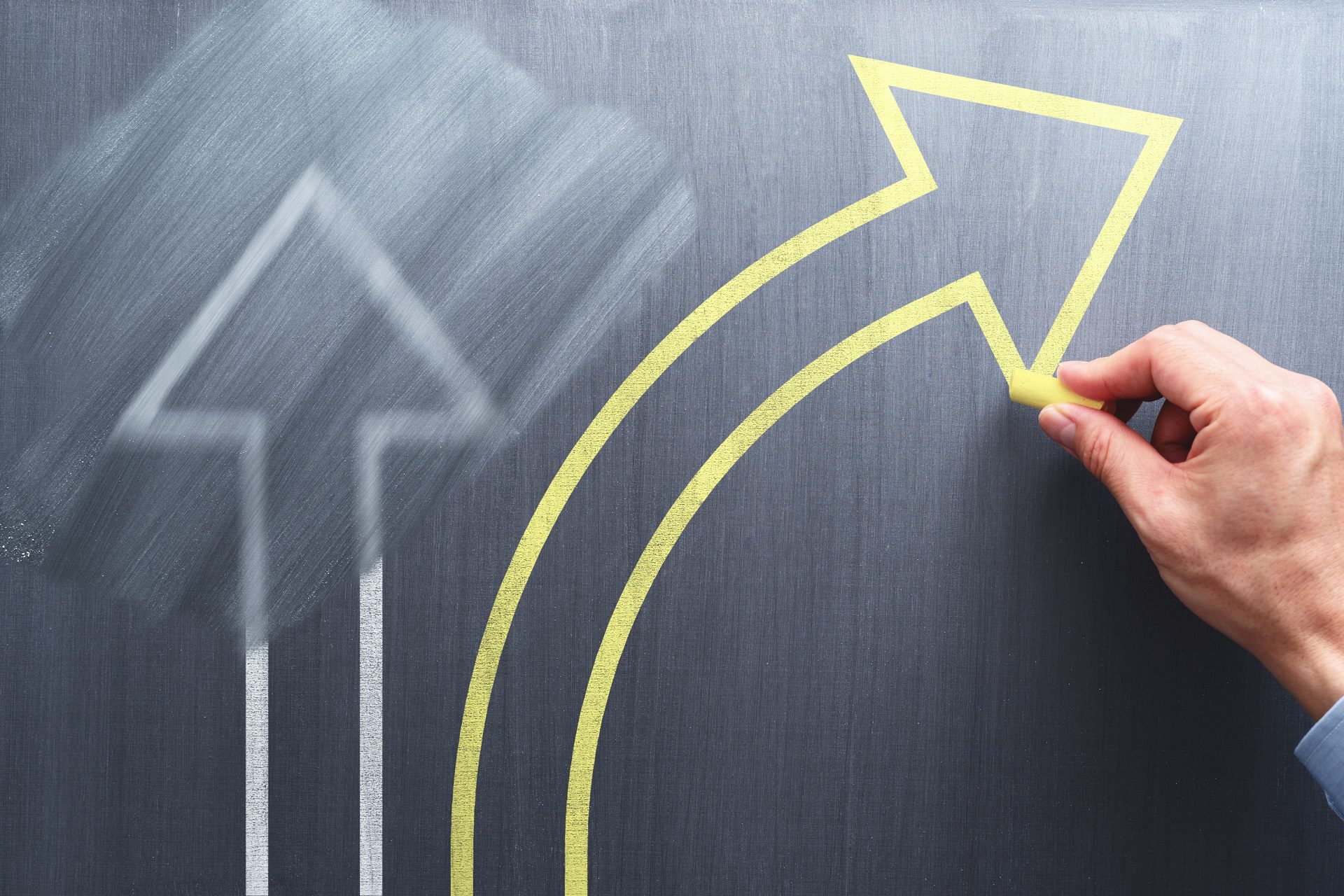 blackboard has a yellow arrow goes to side from a white arrow, symbolizing a better decision for black friday