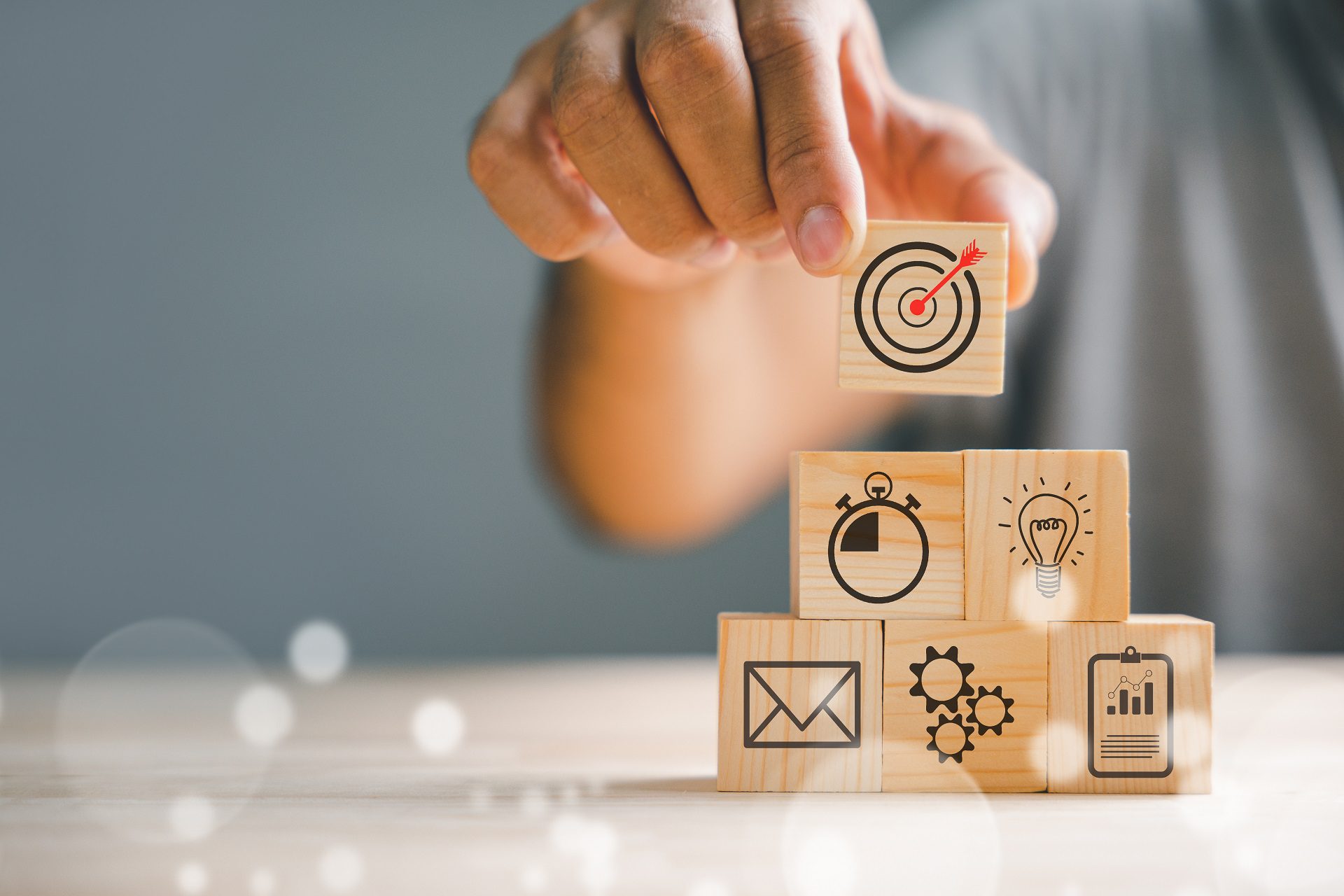 Businessman's hand stacking wood blocks with an icon, depicting the importance of business strategy and Action plan.