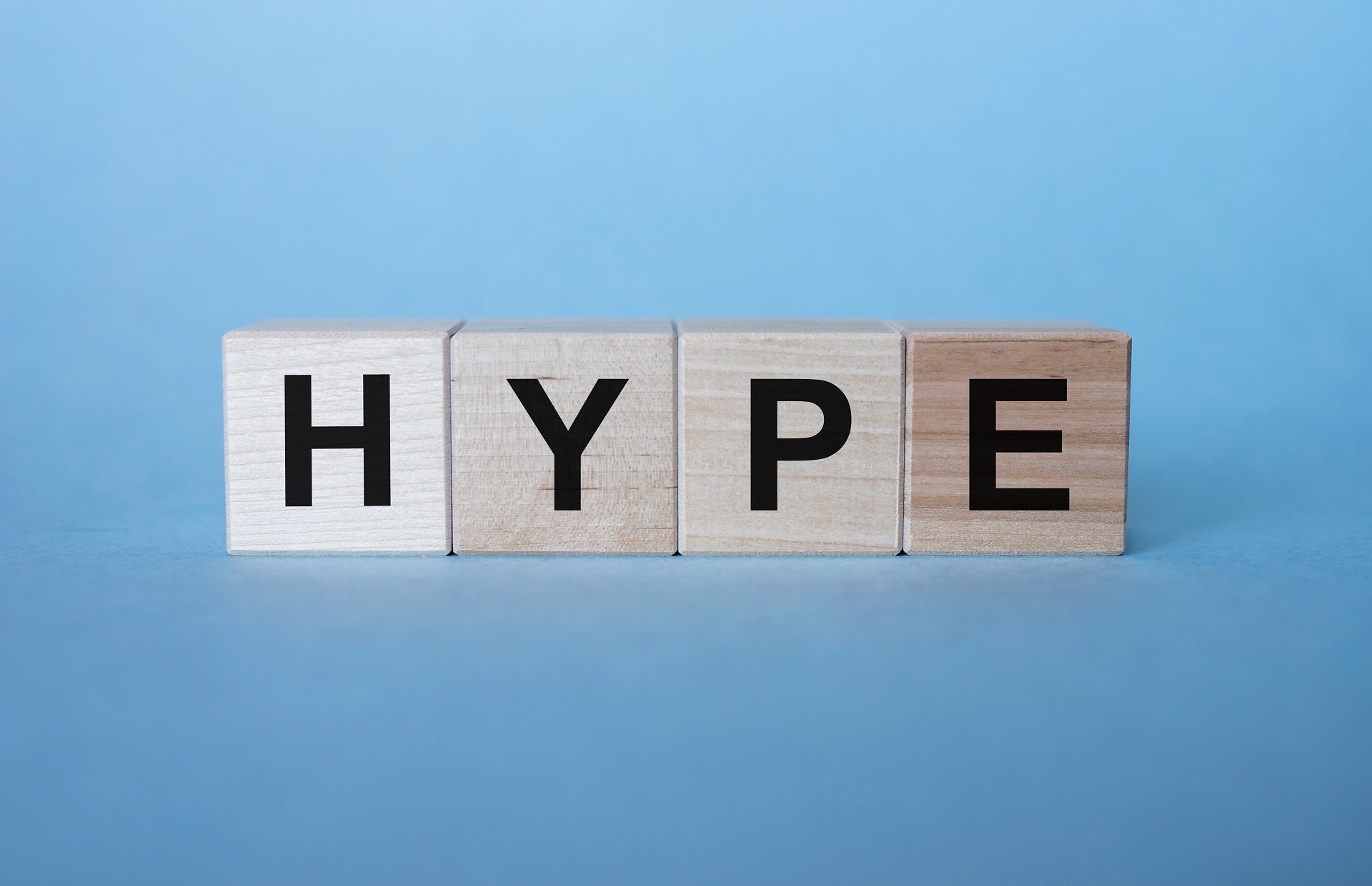 Hype inscription word on wooden cubes on a blue background